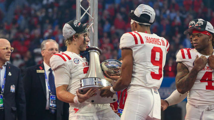 Dec 30, 2023; Atlanta, GA, USA; Mississippi Rebels quarterback Jaxson Dart (2) holds the Peach Bowl trophy as wide receiver Tre Harris (9) catches the top after a victory against the Penn State Nittany Lions at Mercedes-Benz Stadium. Mandatory Credit: Brett Davis-USA TODAY Sports