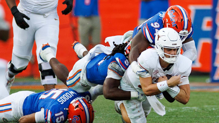 Florida Gators' defensive end Tyreak Sapp (94) and linebacker Myles Graham (5) sack Texas Longhorns quarterback Arch Manning (16).