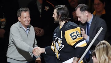 Apr 2, 2023; Pittsburgh, Pennsylvania, USA;  Fenway Sports Group chairman Tom Werner (left) and Pittsburgh Penguins president Kevin Acklin (right) congratulate defenseman Kris Letang (58) before Letang plays in his 1000th career NHL game against the Philadelphia Flyers at PPG Paints Arena. The Penguins won 4-2. Mandatory Credit: Charles LeClaire-Imagn Images