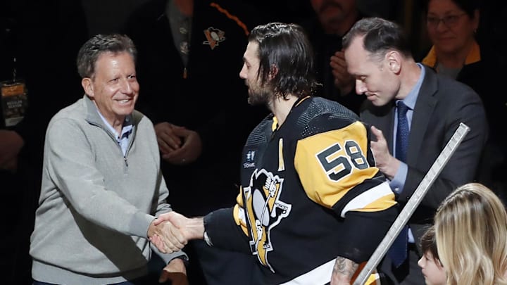 Apr 2, 2023; Pittsburgh, Pennsylvania, USA; Fenway Sports Group chairman Tom Werner (left) and Pittsburgh Penguins president Kevin Acklin (right) congratulate defenseman Kris Letang (58) before Letang plays in his 1000th career NHL game against the Philadelphia Flyers at PPG Paints Arena. The Penguins won 4-2. Mandatory Credit: Charles LeClaire-Imagn Images Apr 2, 2023; Pittsburgh, Pennsylvania, USA; Fenway Sports Group chairman Tom Werner (left) and Pittsburgh Penguins president Kevin Acklin (right) congratulate defenseman Kris Letang (58) before Letang plays in his 1000th career NHL game against the Philadelphia Flyers at PPG Paints Arena. The Penguins won 4-2. Mandatory Credit: Charles LeClaire-Imagn Images