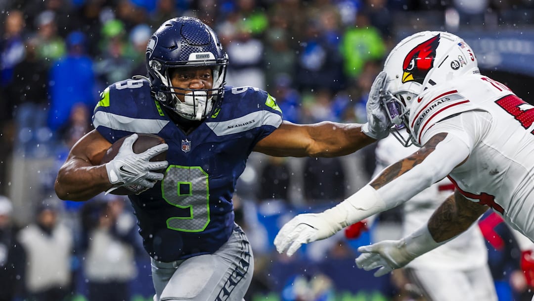 Nov 24, 2024; Seattle, Washington, USA; Seattle Seahawks running back Kenneth Walker III (9) stiff-arms away from a tackle attempt by Arizona Cardinals linebacker Xavier Thomas (54) after catching a pass during the fourth quarter at Lumen Field. 