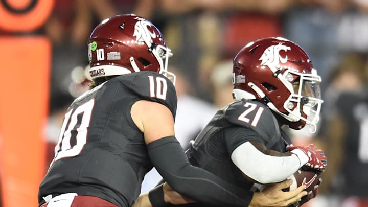 Sep 7, 2024; Pullman, Washington, USA; Washington State Cougars running back Wayshawn Parker (21) takes the hand off from quarterback John Mateer (10) against the Texas Tech Red Raiders in the first half at Gesa Field at Martin Stadium. Mandatory Credit: James Snook-Imagn Images