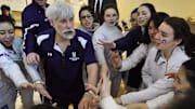 Former Northwestern head coach Laurie Schiller leads a huddle with his Women's Fencing team.