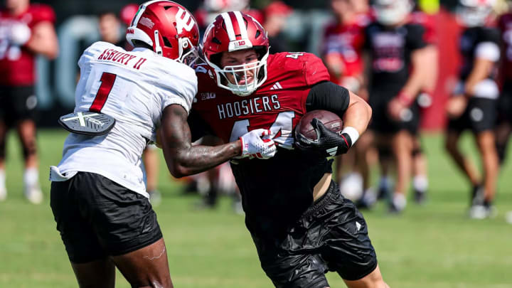 Indiana tight end Zach Horton runs the ball against safety Shawn Asbury II during fall camp.