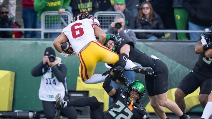 Oregon defensive backs Dillon Thieneman, right, and Jadon Canady bring down USC wide receiver Makai Lemon as the Oregon Ducks host the USC Trojans on Nov. 22, 2025, at Autzen Stadium in Eugene, Oregon.