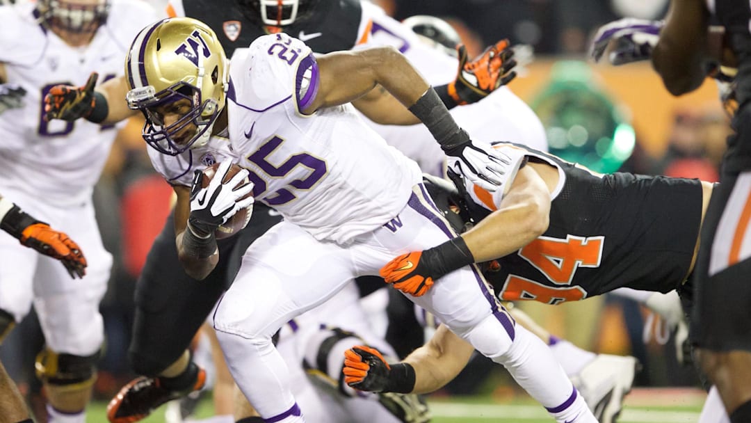 Nov 23, 2013; Corvallis, OR, USA; Washington Huskies running back Bishop Sankey (25) breaks a tackle from Oregon State Beavers defensive end Devon Kell (94) for a touchdown in the first half at Reser Stadium. Mandatory Credit: Jaime Valdez-Imagn Images