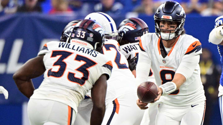 Denver Broncos quarterback Jarrett Stidham (8) hands the ball off to Denver Broncos running back Javonte Williams (33) during the first quarter at Lucas Oil Stadium. 