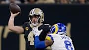 Dec 1, 2024; New Orleans, Louisiana, USA; New Orleans Saints quarterback Derek Carr (4) throws against Los Angeles Rams linebacker Jared Verse (8) during the first half at Caesars Superdome. Mandatory Credit: Matthew Hinton-Imagn Images