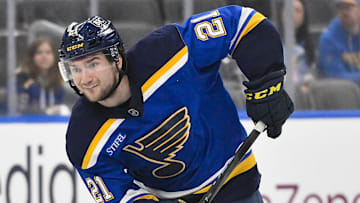 Apr 24, 2025; St. Louis, Missouri, USA; St. Louis Blues right wing Jimmy Snuggerud (21) controls the puck as Winnipeg Jets left wing Kyle Connor (81) defends during the second period in game three of the first round of the 2025 Stanley Cup Playoffs at Enterprise Center. Mandatory Credit: Jeff Curry-Imagn Images