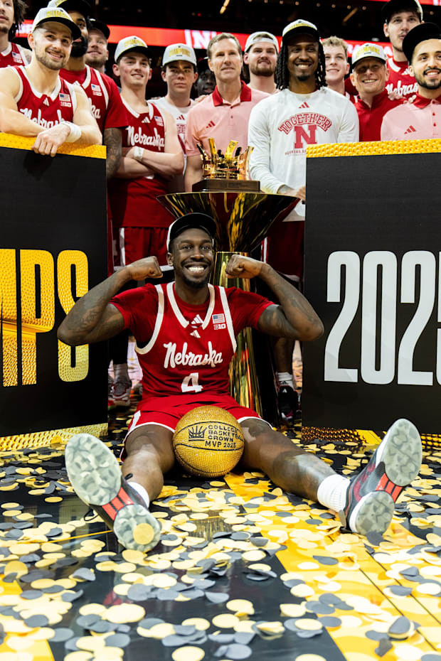 Nebraska forward Juwan Gary sits in front with his MVP ball as the team poses after winning the College Basketball Crown.