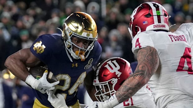 Indiana Hoosiers linebacker Rolijah Hardy (21) and linebacker Aiden Fisher (4) tackle Notre Dame Fighting Irish running back 