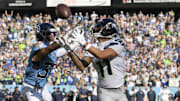 Nov 23, 2025; Nashville, Tennessee, USA; Seattle Seahawks wide receiver Jaxon Smith-Njigba (11) makes a touchdown catch against Tennessee Titans safety Amani Hooker (37) during the first half at Nissan Stadium.