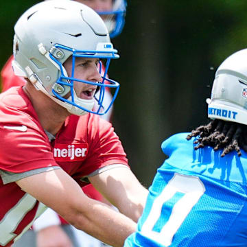 Detroit Lions quarterback Jared Goff (16) hands the ball to running back Jahmyr Gibbs (0) during OTA practice