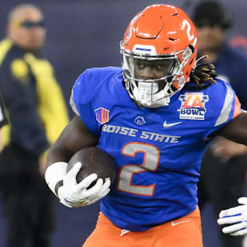 Dec 16, 2023; Inglewood, CA, USA; Boise State Broncos running back Ashton Jeanty (2) stiff arms UCLA Bruins defensive lineman Jake Heimlicher (51) in the first quarter during the Starco Brands LA Bowl at SoFi Stadium. Mandatory Credit: Robert Hanashiro-Imagn Images