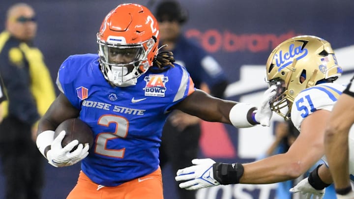 Dec 16, 2023; Inglewood, CA, USA; Boise State Broncos running back Ashton Jeanty (2) stiff arms UCLA Bruins defensive lineman Jake Heimlicher (51) in the first quarter during the Starco Brands LA Bowl at SoFi Stadium. Mandatory Credit: Robert Hanashiro-Imagn Images