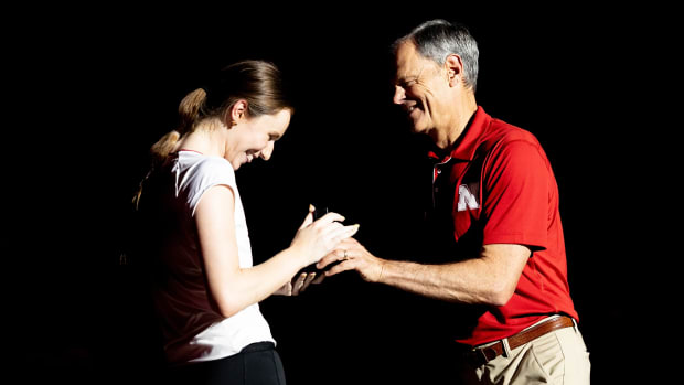 Nebraska volleyball setter Bergen Reilly receivers her Big Ten Conference Championship ring from coach John Cook.