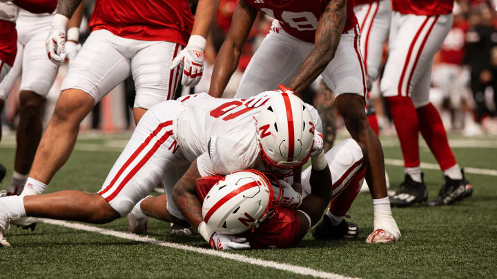 Nebraska football players tackle during the Red-White Spring Game on the FieldTurf of Tom Osborne Field at Memorial Stadium.