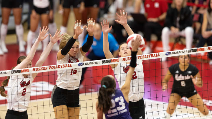 Nebraska Cornhuskers Bergen Reilly, Andi Jackson, and Lindsay Krause leap to block a TCU attack.