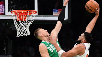 Feb 23, 2025; Boston, Massachusetts, USA;  New York Knicks center Karl-Anthony Towns (32) attempts to dunk the ball over Boston Celtics center Kristaps Porzingis (8) during the second half at TD Garden. Mandatory Credit: Bob DeChiara-Imagn Images