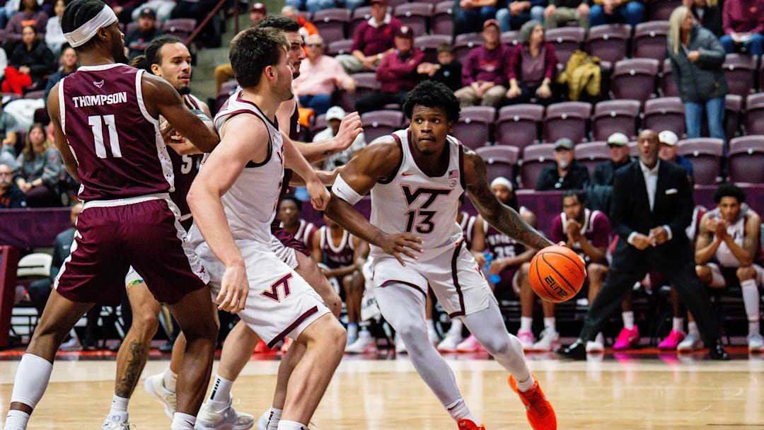 Amani Hansberry brings the ball into the paint with Christian Gurdak beside.