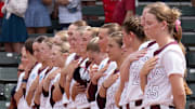 The Hokies stand in line down the base path during the national anthem.