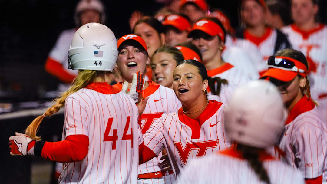 Rachel Castine (44) returns to the dugout with a celebration from her teammates. 