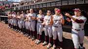 Cori McMillan runs out of the dugout to run down the line, giving her teammates high-fives.