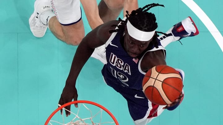 Jul 28, 2024; Villeneuve-d'Ascq, France; United States guard Jrue Holiday (12) shoots against Serbia shooting guard Ognjen Dobric (13) in the second quarter during the Paris 2024 Olympic Summer Games at Stade Pierre-Mauroy. Mandatory Credit: John David Mercer-USA TODAY Sports