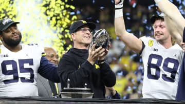 Dec. 4, 2021: Michigan coach Jim Harbaugh raises the trophy after the Wolverines' 42-3 win over Iowa