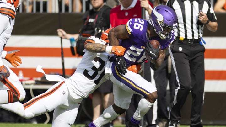 Aug 17, 2024; Cleveland, Ohio, USA; Minnesota Vikings running back Kene Nwangwu (26) runs the ball as Cleveland Browns cornerback Vincent Gray (31) tackles him during the first quarter at Cleveland Browns Stadium.