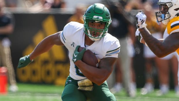 Tulane Green Wave running back Mekhi Hughes on a rushing attempt during a college football game.