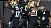CU football head coach Deion Sanders and his son Shilo Sanders, who's the starting safety, share a hug on the sideline after Shilo's interception and touchdown early in the Rocky Mountain Showdown.
