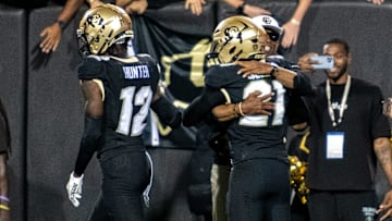 CU football head coach Deion Sanders and his son Shilo Sanders, who's the starting safety, share a hug on the sideline after Shilo's interception and touchdown early in the Rocky Mountain Showdown.