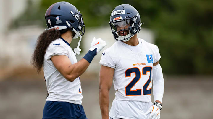 Denver Broncos safeties Talanoa Hufanga (9) and Brandon Jones (22) chat during a voluntary minicamp practice in May of 2025.