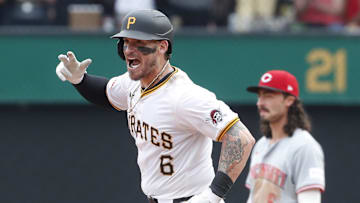 Aug 25, 2024; Pittsburgh, Pennsylvania, USA;  Pittsburgh Pirates catcher Yasmani Grandal (6) gestures as he circles the bases on a game winning walk-off two run home run as Cincinnati Reds second baseman Jonathan India (6) reacts during the ninth inning at PNC Park. Mandatory Credit: Charles LeClaire-Imagn Images