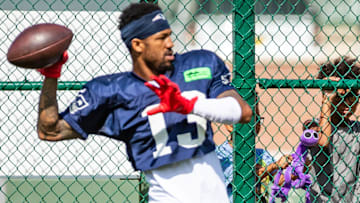 A young fan watches New England Patriots defensive back Jack Jones (13) from behind a fence at