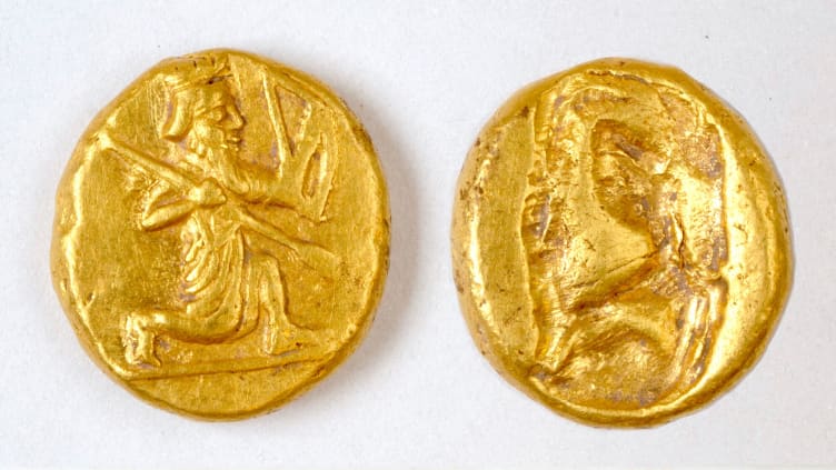 The coins show a figure of a kneeling archer.