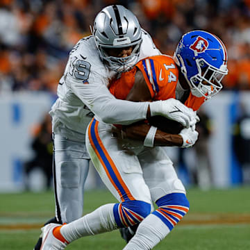 Nov 6, 2025; Denver, Colorado, USA; Denver Broncos wide receiver Courtland Sutton (14) is tackled by Las Vegas Raiders defensive end Charles Snowden (49) in the fourth quarter at Empower Field at Mile High. 
