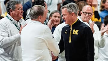 Michigan State head coach Tom Izzo, left, shakes hands with Michigan head coach Dusty May after 79-62 win at Breslin Center in East Lansing on Sunday, March 9, 2025.
