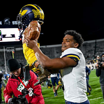 Michigan's Will Johnson celebrates with the Paul Bunyan trophy after beating Michigan State on Saturday, Oct. 21, 2023, at Spartan Stadium in East Lansing.