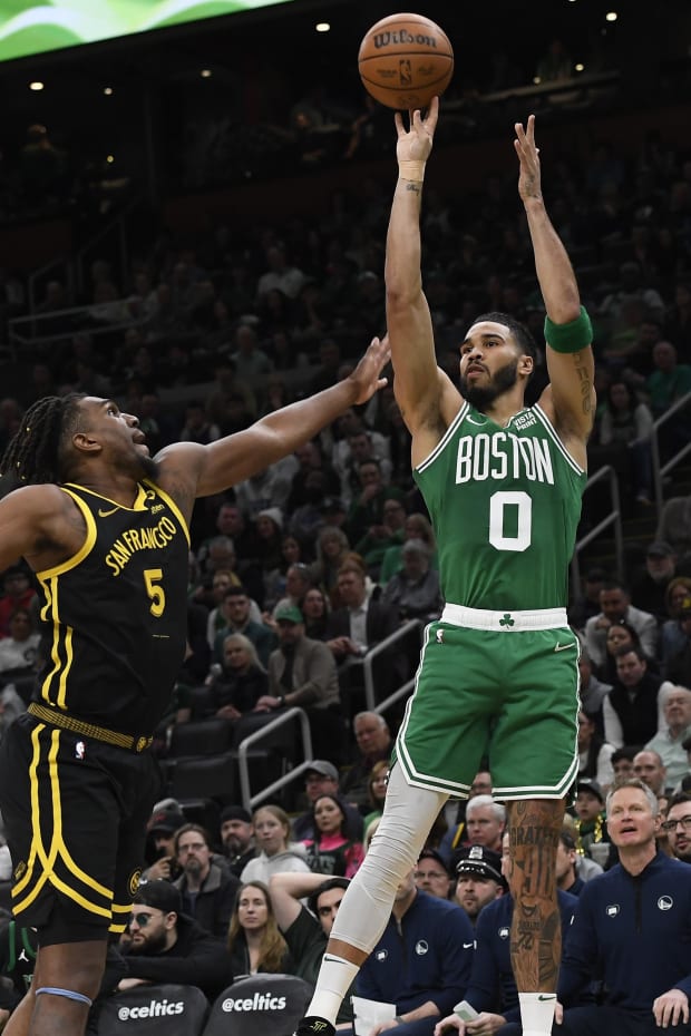 Boston Celtics forward Jayson Tatum (0) shoots the ball over Golden State Warriors forward Kevon Looney (5).