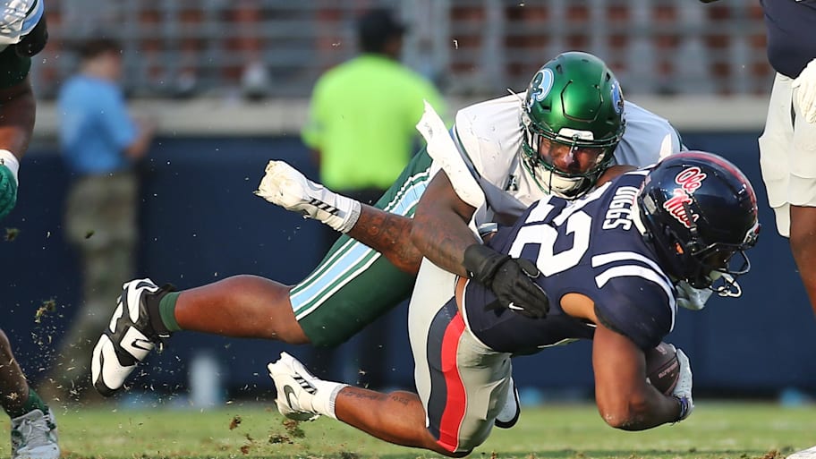 Tulane Green Wave defensive linemen Eliyt Nairne tackles Mississippi Rebels running back Logan Diggs.
