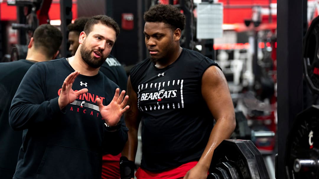 Cincinnati Bearcats Football Sports Performance director Niko Palazeti speaks with Cincinnati Bearcats defensive lineman Dominique Perry during a weight lifting session on at The Lindner Center in Cincinnati on Thursday, Feb. 9, 2023.

Ncaa Basketball Portrait Photos For Niko Palazeti Profile