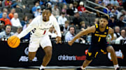 Cincinnati Bearcats guard Day Day Thomas (1) handles the ball as West Virginia Mountaineers guard Noah Farrakhan (1) defends in the first half of the Big 12 Conference tournament between Cincinnati Bearcats and West Virginia Mountaineers at T-Mobile Center in Kansas City, Mo., on Tuesday, March 12, 2024.