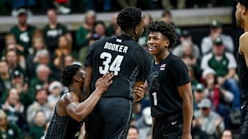 Michigan State's Xavier Booker, center, celebrates his dunk with teammates Tyson Walker, left, and