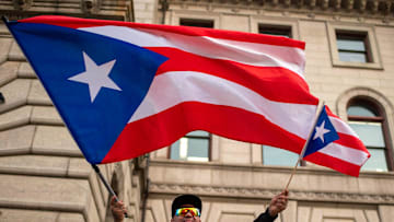 Tony Rivera of Worcester waves flags during a rally for Puerto Rico at City Hall Wednesday.