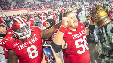 Indiana's Mike Katic (56) and CJ West (8) celebrate with the Old Oaken Bucket after the Indiana versus Purdue football game at Memorial Stadium on Saturday, Nov. 30, 2024.