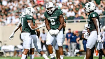 Michigan State's Simeon Barrow Jr., center, celebrates his sack against Richmond during the first