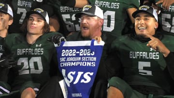 Manteca head coach Mark Varnum, center, holds the section banner between players Blake Nichelson, left and Alijah Cota after they defeated Granite Bay 51-48 in the CIF Sac-Joaquin Section Division II football championship game at Hughes Stadium in Sacramento on Saturday, Nov. 26, 2022.

Fb Granite Manteca 1193a