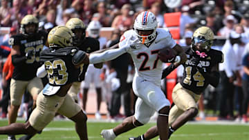 Sep 20, 2025; Blacksburg, Virginia, USA;  Virginia Tech Hokies running back Marcellous Hawkins (27) runs the ball as Wofford Terriers cornerback Cole Walker (23) defends during the first quarter at Lane Stadium. Mandatory Credit: Brian Bishop-Imagn Images